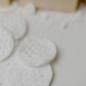 A close-up of textured cotton pads for skincare and exfoliation in a minimalist style.